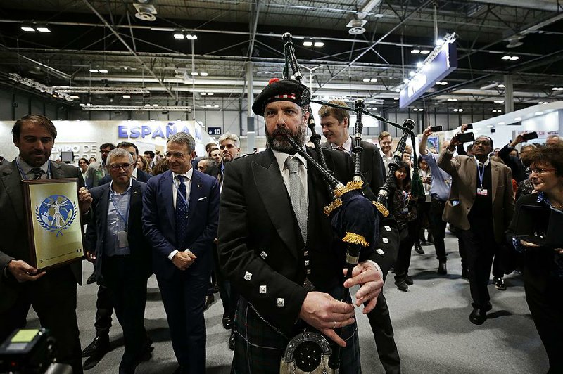 A bagpipe player accompanies a British delegation Friday during the Madrid climate talks to promote the next climate gathering, which is to be held in Glasgow, Scotland. More photos are available at arkansasonline.com/1214climate/  