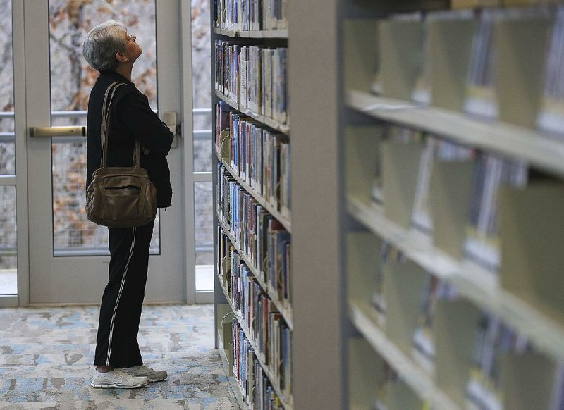 FILE — Barbara Brockinton looks for a book Friday Dec. 13, 2019 during a visit to the Central Arkansas Library System Amy Sanders Library in Sherwood.  (Arkansas Democrat-Gazette/STATON BREIDENTHAL)  