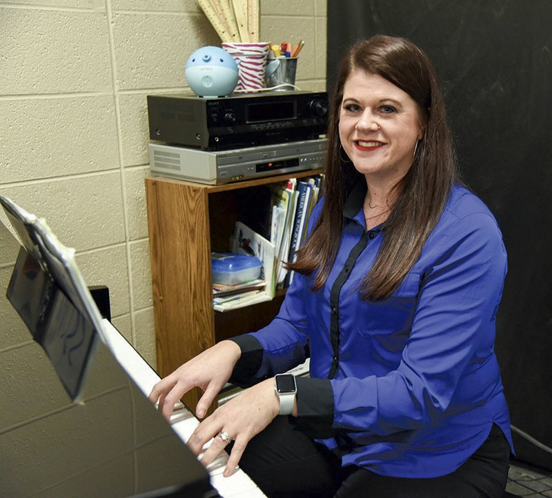 Lakeside Middle School choir teacher Amber Moss has her portrait taken at her piano inside of her classroom. - Photo by Grace Brown of the Sentinel-Record.