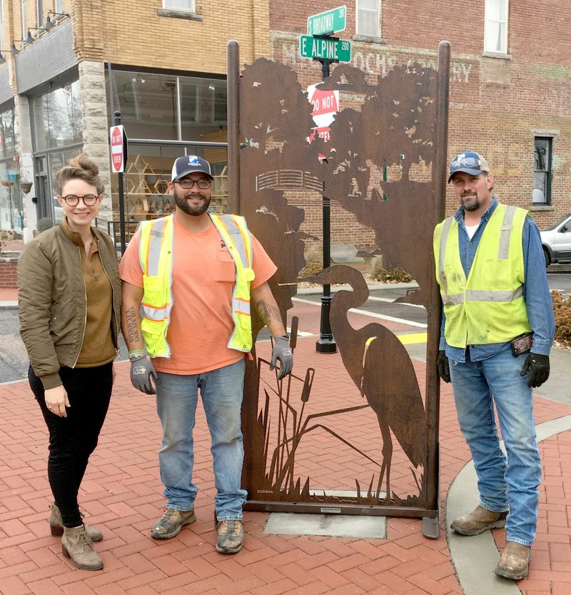 Photo Submitted Main Street Siloam Director Kelsey Howard (left) poses with two city workers following the installation of the heron sculpture.