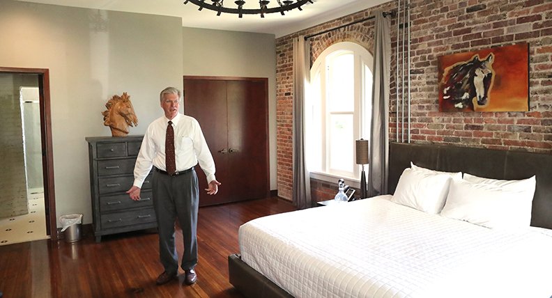 Hot Springs Mayor Pat McCabe, who leased the Hale Bath House from the National Park Service with his wife, Ellen, gives a tour of one of the rooms during the grand opening in August. The hotel will receive the 2019 Excellence in Preservation through Rehabilitation Award in January. - Photo by Richard Rasmussen of The Sentinel-Record