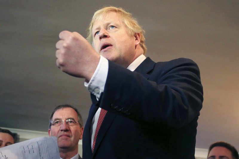 Britain's Prime Minister Boris Johnson, gestures as he speaks to supporters on a visit to meet newly elected Conservative party MP for Sedgefield, Paul Howell, at Sedgefield Cricket Club in County Durham, north east England, Saturday Dec. 14, 2019, following his Conservative party's general election victory. Johnson called on Britons to put years of bitter divisions over the country's EU membership behind them as he vowed to use his resounding election victory to finally deliver Brexit. (Lindsey Parnaby/Pool via AP)