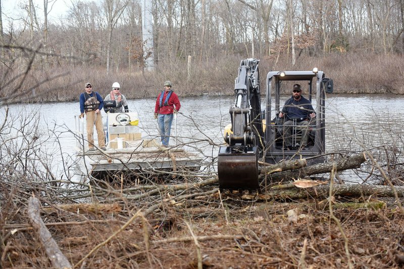 NWA Democrat-Gazette/FLIP PUTTHOFF 
Workers with Southwestern Electric Power Co. and Arkansas Game and Fish Commission remove trees on Dec. 4 2019 around the Flint Creek Power Plant and sink them in Swepco Lake. Thinning some trees improves forest health and the submerged timber is good for fish.