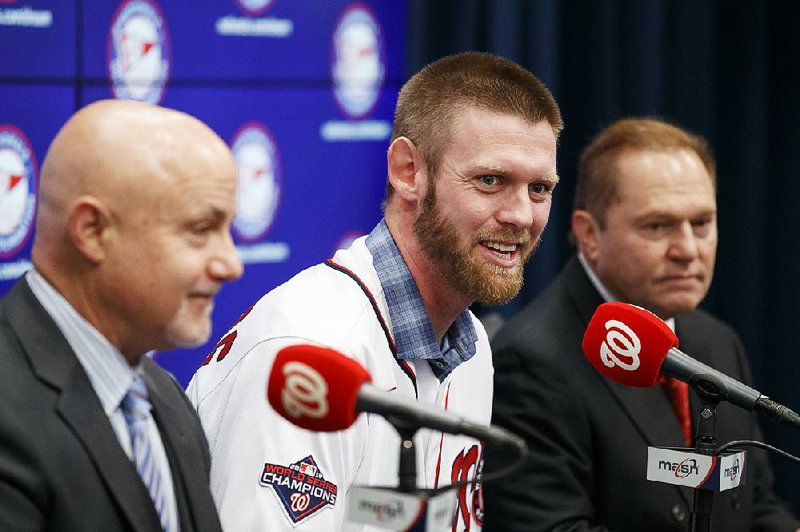 Pitcher Stephen Strasburg (center) opted out of his contract to test the free agent market, but he signed a new deal with the Washington Nationals that could allow him to play his entire career with the team.
(AP/Alex Brandon)