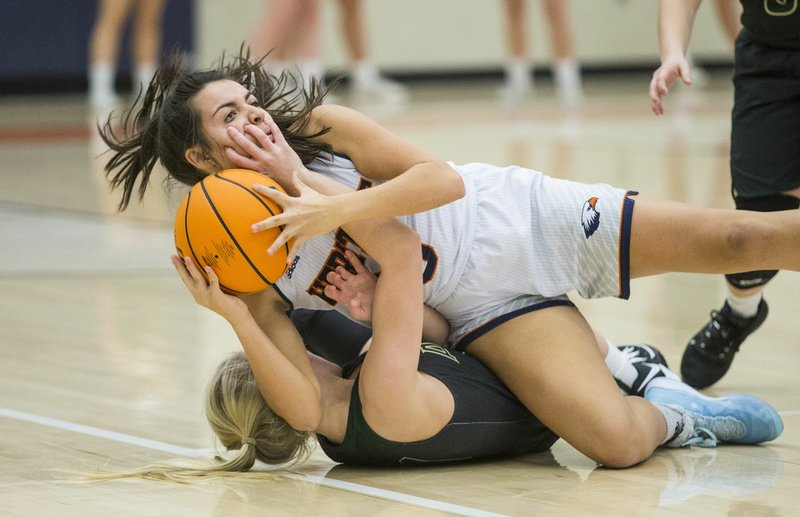 NWA Democrat-Gazette/BEN GOFF @NWABENGOFF Jazmine Perez (top) of Rogers Heritage and Halyn Carmack of Alma try to gain control of a loose ball Tuesday, Dec. 17, 2019, at War Eagle Arena in Rogers. Go to http://bit.ly/2Pvyw6u to see more photos.