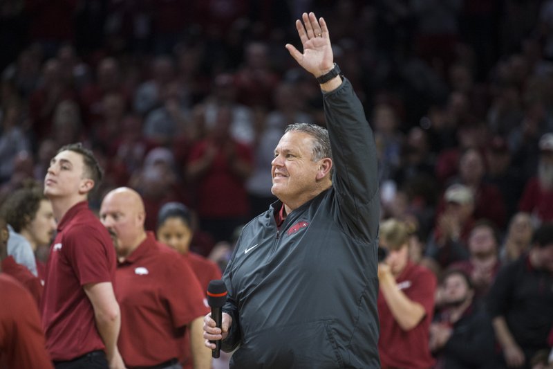 Arkansas football head coach Sam Pittman greets fans Saturday during a timeout in the basketball game at Walton Arena in Fayetteville. Pittman has a tough recruiting job ahead with the early signing period, which starts today and runs through Friday. - Photo by Ben Goff of the NWA Democrat-Gazette