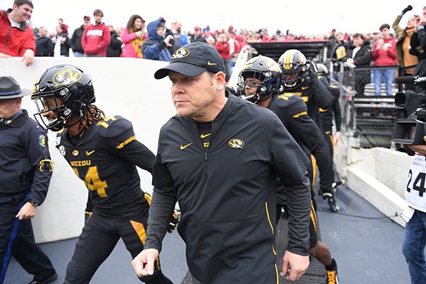 Missouri head coach Barry Odom leads his team onto the field to play Arkansas during an NCAA college football game, Friday, Nov. 29, 2019 in Little Rock. (AP Photo/Michael Woods)	