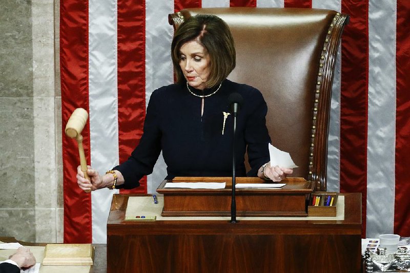 House Speaker Nancy Pelosi strikes the gavel Wednesday night after announcing passage of the second article of impeachment against President Donald Trump. Pelosi would not say when the House will send the articles to the Senate for trial. “We’ll see” whether the Senate announces terms she considers fair, she told reporters. More photos at arkansasonline.com/1219impeachment/.
(AP/Patrick Semansky)