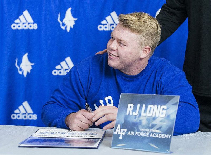 Rogers offensive lineman R.J. Long prepares to sign his national letter of intent Wednesday to play football at the Air Force Academy next season. More photos are available at arkansasonline.com/1219long.
(NWA Democrat-Gazette/Ben Goff)