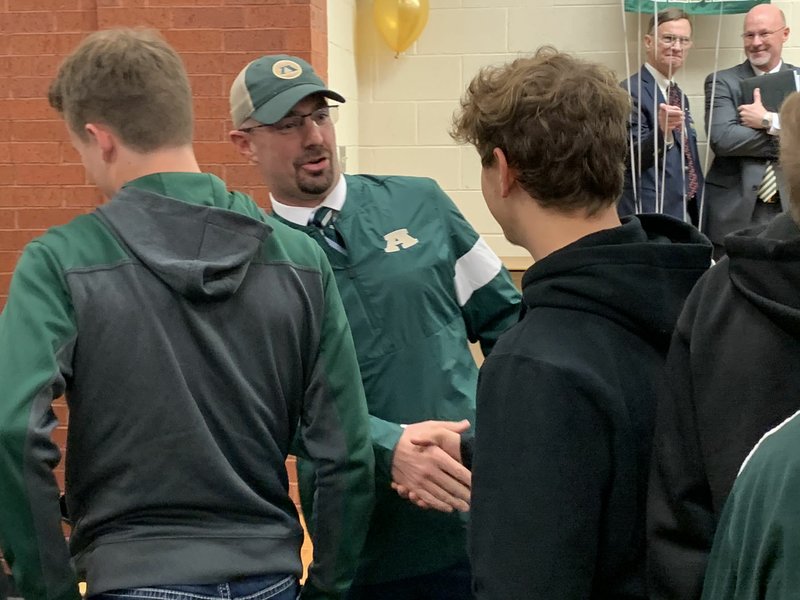 New Alma football coach Rusty Bush (center) meets with Airedale players following Thursday afternoon's press conference at the school.