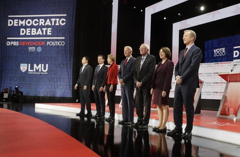 Democratic presidential candidates from left, entrepreneur Andrew Yang, South Bend Mayor Pete Buttigieg, Sen. Elizabeth Warren, D-Mass., former Vice President Joe Biden, Sen. Bernie Sanders, I-Vt., Sen. Amy Klobuchar, D-Minn., and businessman Tom Steyer stand on stage before a Democratic presidential primary debate Thursday, Dec. 19, 2019, in Los Angeles, Calif. (AP Photo/Chris Carlson)