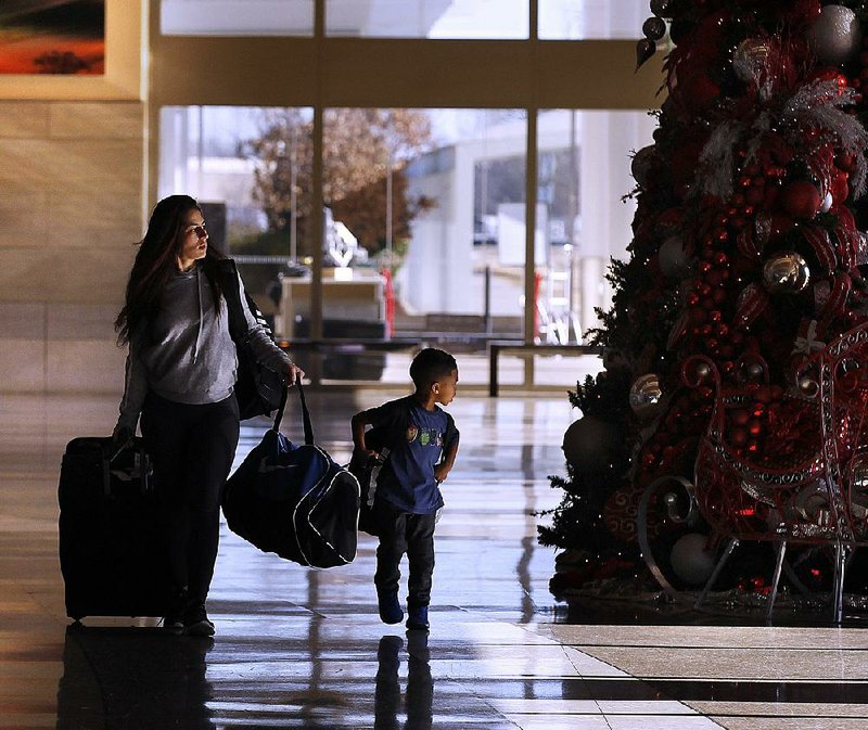 Rabea Epps and her son, Jayden, 4, of Hot Springs head to the ticket counter Thursday at Bill and Hillary Clinton National Airport before flying out on a holiday trip.
(Arkansas Democrat-Gazette/Thomas Metthe)