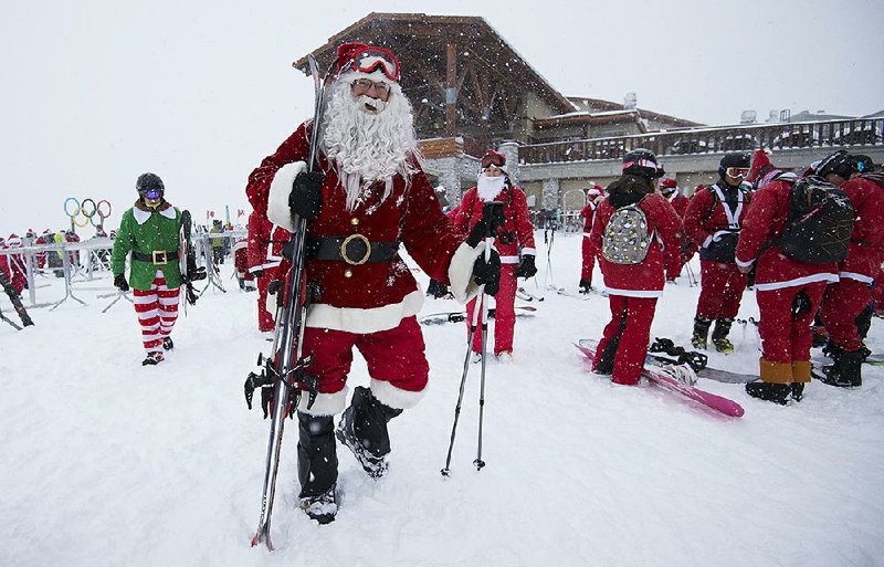 People dressed in Santa Claus regalia enjoy some fresh powder Friday during the annual Santa Ski in Whistler in Canada’s British Columbia province.  