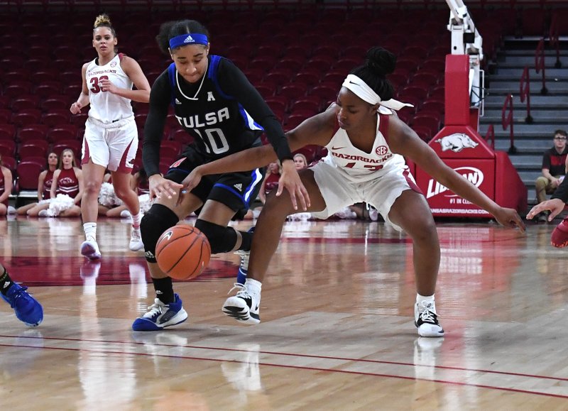 Arkansas’ Makayla Daniels fights for possession of the ball with Tulsa’s Kendrian Elliott in a Dec. 11 game at Bud Walton Arena in Fayetteville. - Photo by J.T. Wampler of the NWA Democrat-Gazette