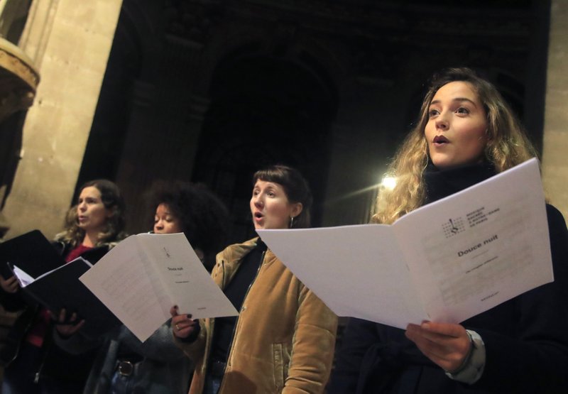 In this photo taken Monday, Dec. 16, 2019, members of the Notre Dame cathedral choir sing during a rehearsal at the Saint Sulpice church in Paris. Notre Dame Cathedral kept holding services during two world wars as a beacon of hope amid bloodshed and fear. It took a fire in peacetime to finally stop Notre Dame from celebrating Christmas Mass for the first time in more than two centuries. (AP Photo/Michel Euler)