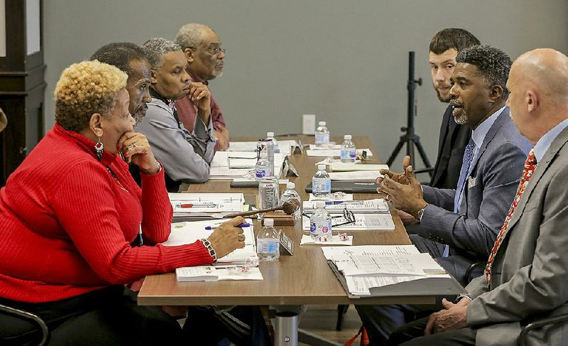 Anthony Snell (second from right), executive director of the Metropolitan Housing Alliance, presents his executive report last week during a meeting of the housing agency’s board of commissioners in Little Rock. 