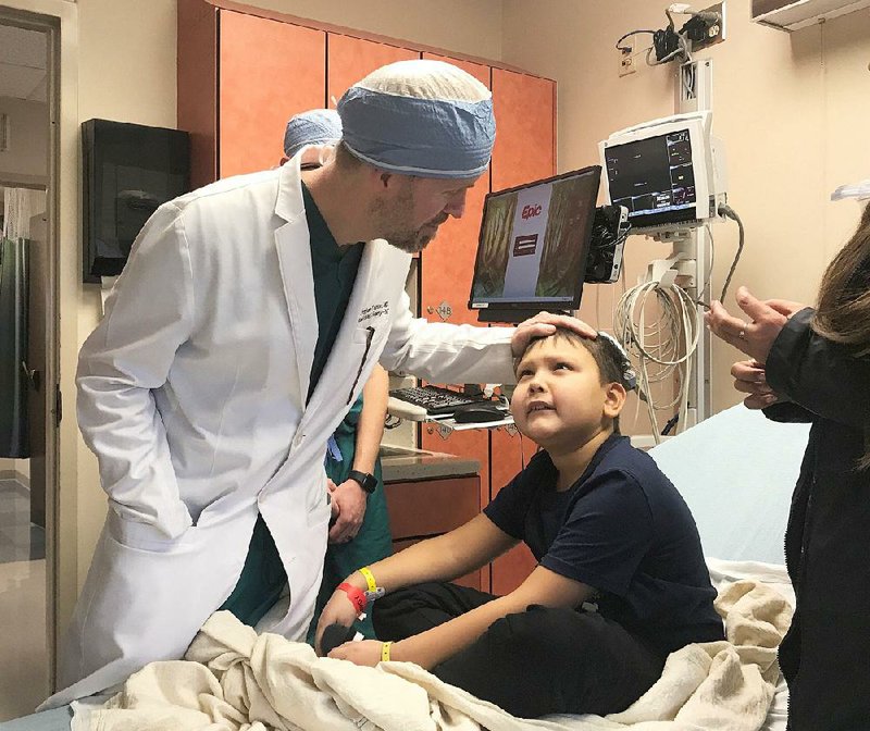 Dr. Gresham Richter, professor and pediatric otolaryngology chief at the University of Arkansas for Medical Sciences and Arkansas Children’s Hospital, talks with 8-year-old Mikhail on Oct. 29, in advance of a procedure to treat a venous malformation.
(Arkansas Democrat-Gazette/Kat Stromquist)