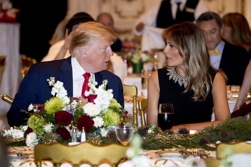 President Donald Trump and first lady Melania Trump talk at Mar-a-lago while there for Christmas Eve dinner in Palm Beach, Fla., Tuesday, Dec. 24, 2019. (AP Photo/Andrew Harnik)