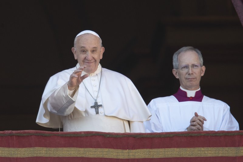 Pope Francis, flanked by Mons. Guido Marini, the Vatican master of liturgical ceremonies, waves to faithful and pilgrims after he delivered a Christmas blessing from the main balcony of St. Peter's Basilica at the Vatican, Wednesday, Dec. 25, 2019. (AP Photo/Alessandra Tarantino)