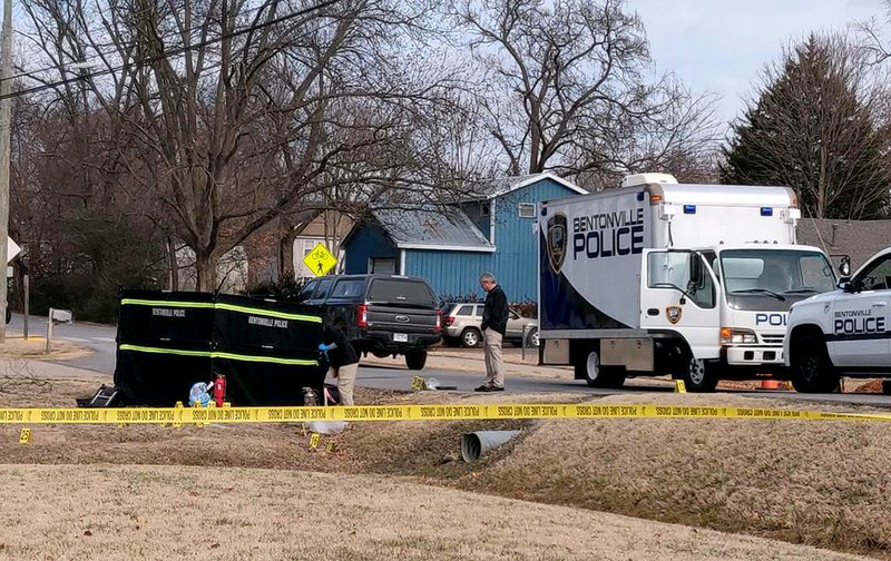 Bentonville police officers collect evidence at the scene of a fatal stabbing Thursday in Bentonville.