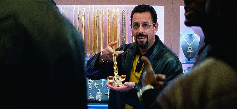Hustling jeweler Howard Ratner (Adam Sandler) shows off one of his signature items, a gold-and-diamond-encrusted Furby, in Uncut Gems, the kinetic new action movie from brothers Josh and Benny Safdie.