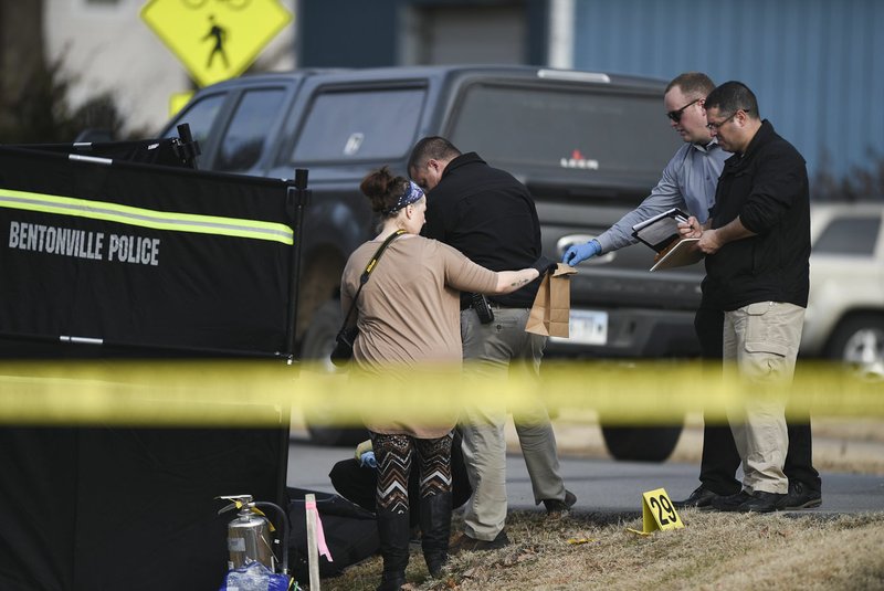 NWA Democrat-Gazette/CHARLIE KAIJO Officers collect evidence Thursday following a stabbing near an apartment complex on 502 S.E. B St. in Bentonville.