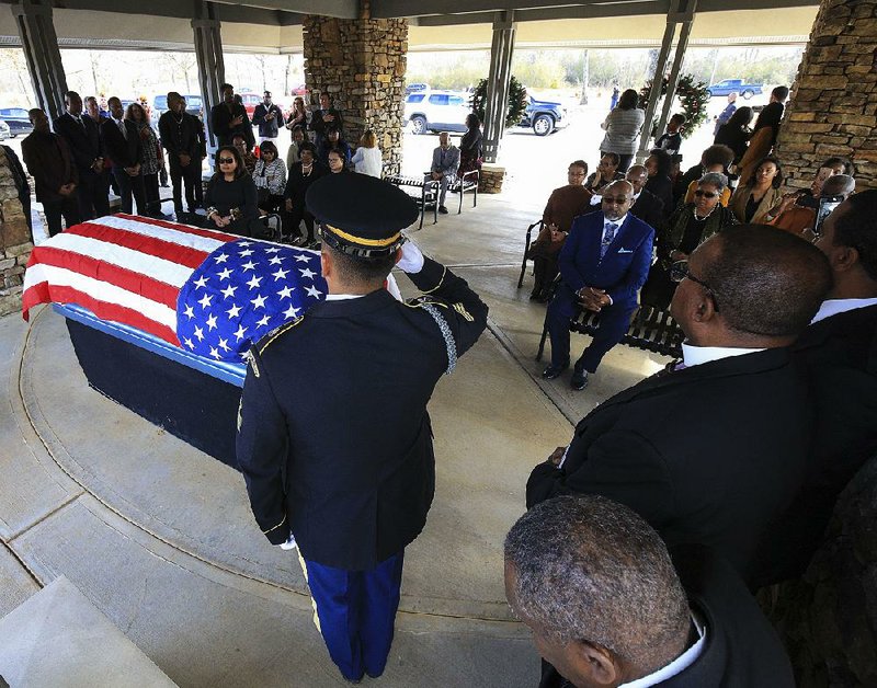 Arkansas National Guard Sgt. Johnny Mosso salutes during the playing of taps as a funeral was held Friday at the Arkansas State Veterans Cemetery in North Little Rock for Benjamin Haymon, the state’s oldest veteran. More photos at arkansasonline.com/1228haymon/.
(Arkansas Democrat-Gazette/Staton Breidenthal)