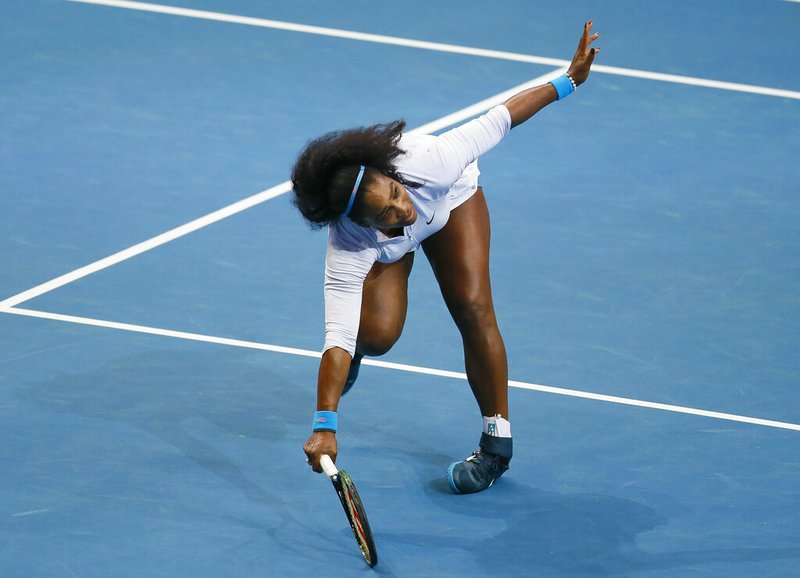 This Dec. 7, 2015, file photo shows USA's Serena Williams tripping as she returns a shot to Croatia's Mirjana Lucic-Baroni of Japan Warriors in the women's singles match of the 2015 International Premier Tennis League at suburban Pasay city south of Manila, Philippines. Williams has been voted the AP Female Athlete of the Decade for 2010 to 2019. Williams won 12 of her professional-era record 23 Grand Slam singles titles over the past 10 years. No other woman won more than three in that span. She also tied a record for most consecutive weeks ranked No. 1 and collected a tour-leading 37 titles in all during the decade. Gymnast Simone Biles finished second in the vote by AP member sports editors and AP beat writers. Swimmer Katie Ledecky was third, followed by ski racers Lindsey Vonn and Mikaela Shiffrin. (AP Photo/Bullit Marquez, File)