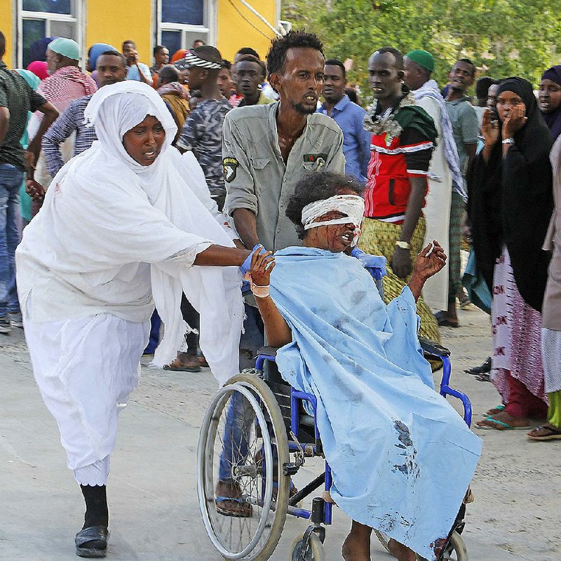 People move a civilian wounded in Saturday’s truck bombing in Mogadishu, Somalia, to be trans- ported to a hospital. The bombing occurred at a security checkpoint during morning rush hour. More photos at arkansasonline.com/1229blast/. 