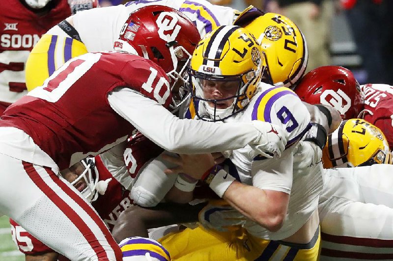 LSU quarterback Joe Burrow (9) scores on a 3-yard run in the third quarter of the Peach Bowl against Oklahoma on Saturday in Atlanta. Burrow threw for 493 yards and seven touchdowns to lead the Tigers to a 63-28 victory and a spot in the College Football Playoff championship. LSU will face Clemson for the title on Jan. 13 in New Orleans.