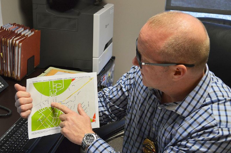 Mike Cooke, the sex offender manager for the North Little Rock Police Department, points at a map that he sometimes gives registrants who are looking for places live. 