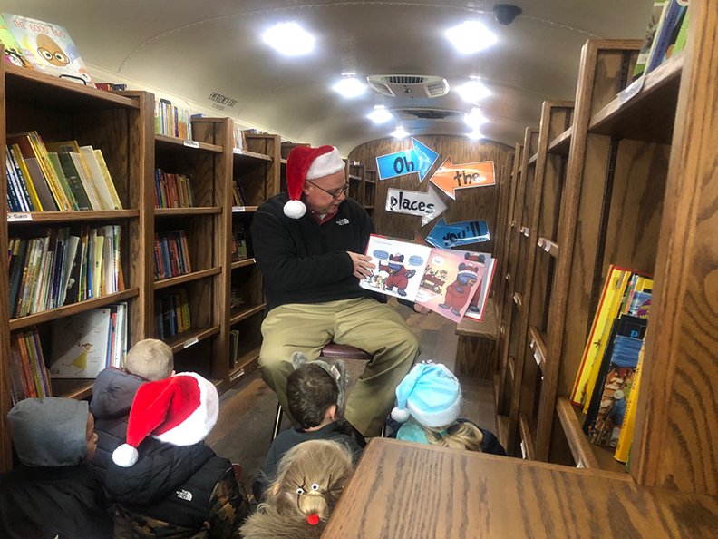 Lake Hamilton School District Superintendent Shawn Higginbotham, wearing a Santa hat, recently surprised the students in the Wolf Pack Reading Den by joining in a reading of "Santa Bruce." - Submitted photo