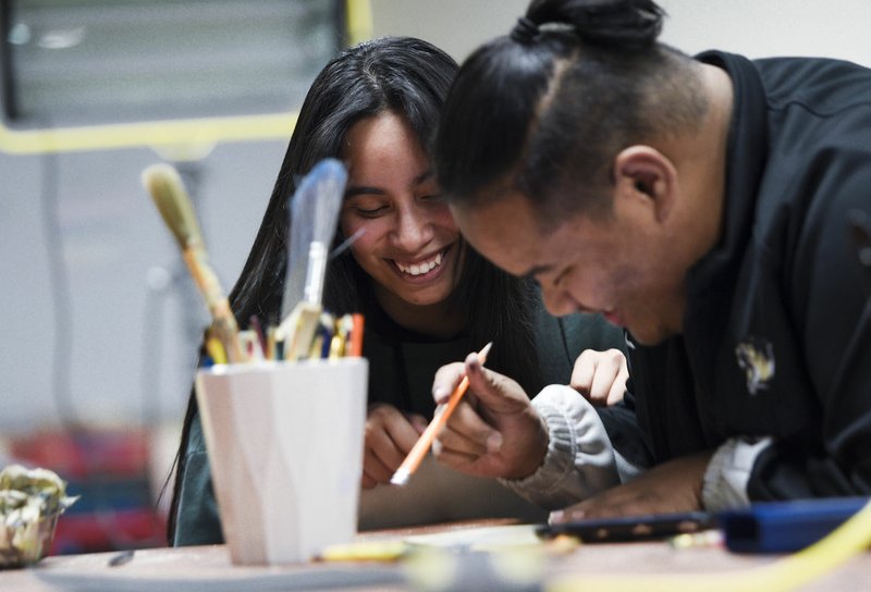 NWA Democrat-Gazette/CHARLIE KAIJO Marshallese artist Joyce Hitchfield (left) and Raygon Jacklick, 17, of Springdale work on an art project, Dec. 13 at The Station in Springdale.