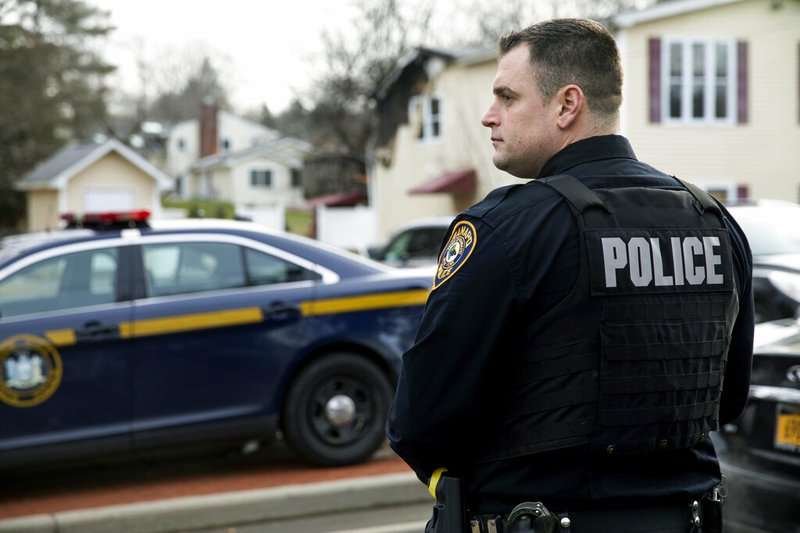 A Ramapo police officer directs traffic outside a rabbi's residence in Monsey, N.Y., Sunday, Dec. 29, 2019, following a stabbing at the home Saturday night during a Hannukah celebration.
