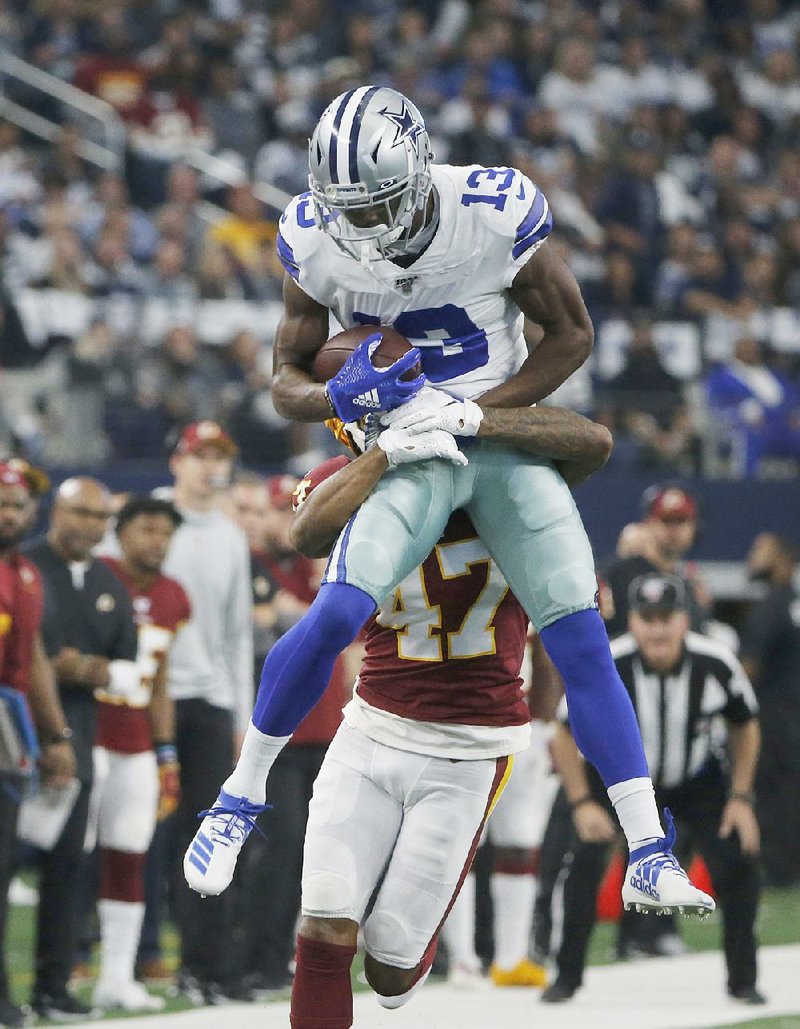 Dallas wide receiver Michael Gallup makes a catch over Washing- ton Redskins cornerback Aaron Colvin during the first half Sunday in Arlington, Texas. Gallup caught three touchdown passes in a 47-16 victory for the Cowboys, who failed to make the playoffs.