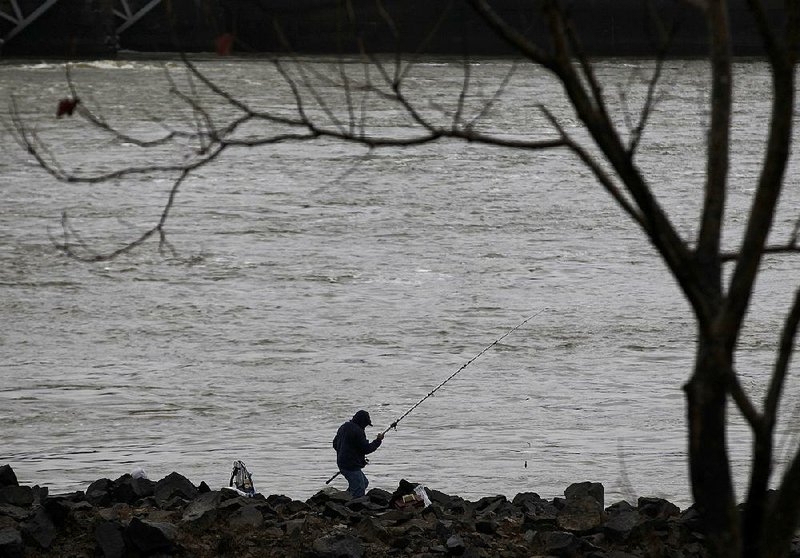 A fisherman casts his line into the Arkansas River while fishing from the rocks near the David D. Terry Lock and Dam on Sunday, Dec. 29, 2019. 
(Arkansas Democrat-Gazette/Thomas Metthe)