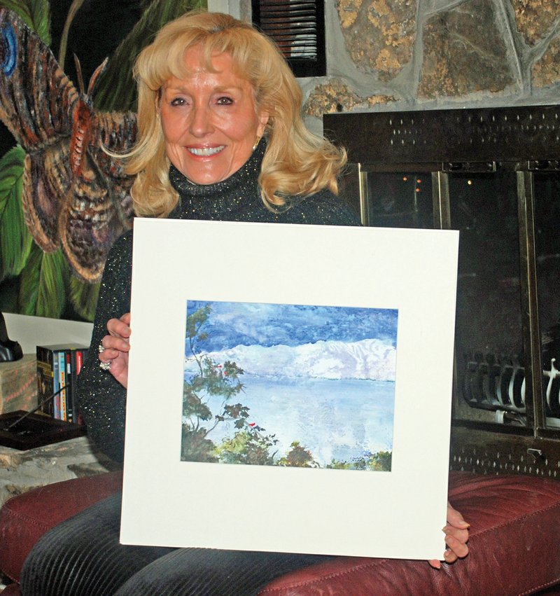 Charlotte Bailey Rierson of Fairfield Bay received a purchase award in the 2020 Small Works on Paper touring exhibition. She is holding the prize-winning painting she calls Reflections of Winter Series 1, Winter’s Kiss.