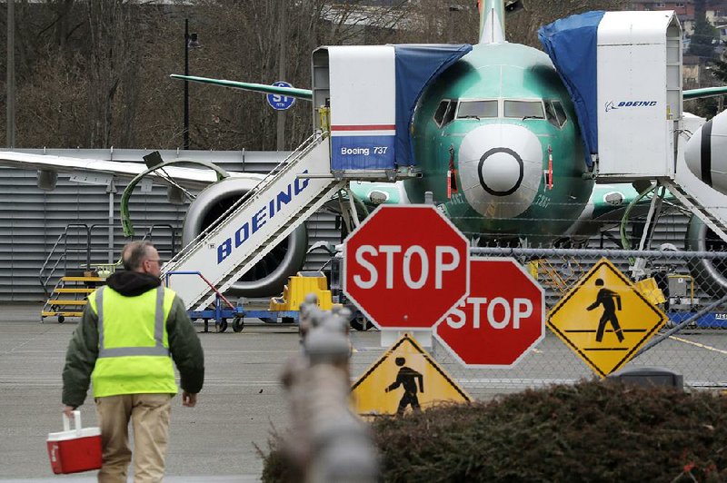A worker at a Boeing facility in Renton, Wash., walks toward a 737 Max jet earlier this month.