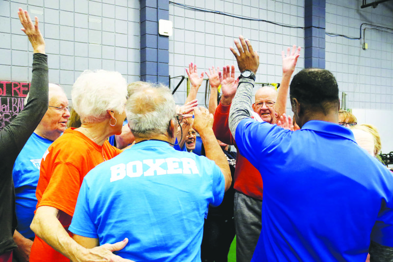 Boxers, cornermen, volunteers and coaches sign off after a workout on the second floor of HealthWorks Fitness Center Nov. 13. The group makes up the members of the Rock Steady program, which aims to stop and reverse the onset of Parkinson's Disease. story.lead_photo.caption