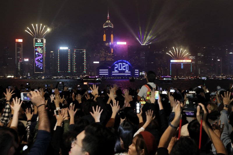 Protesters hold up their hands to symbolize the five demands of the pro-democracy movement as New Year's fireworks light up the sky during a demonstration in Hong Kong, Wednesday, Jan. 1, 2020. Chinese President Xi Jinping in a New Year's address Tuesday has called for Hong Kong to return to stability following months of pro-democracy protests that began in June over a proposed extradition law, and have spread to include other grievances and demands for more democracy. (AP Photo/Lee Jin-man)

