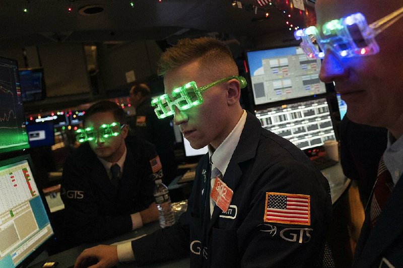 Stock traders wear New Year’s 2020 party glasses Tuesday at the New York Stock Exchange. Stocks slipped globally in quiet New Year’s Eve trading with many markets closed.
(AP/Mark Lennihan)