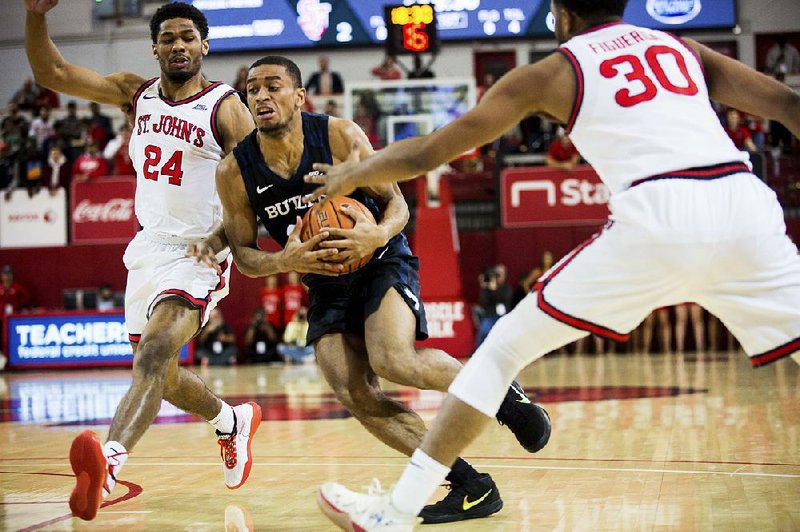 Butler guard Aaron Thompson (center) drives to the basket Tuesday between St. John’s guards Nick Rutherford (24) and LJ Figueroa during the No. 11 Bulldogs’ 60-58 victory over the Red Storm in New York.
(AP/Julius Constantine Motal)