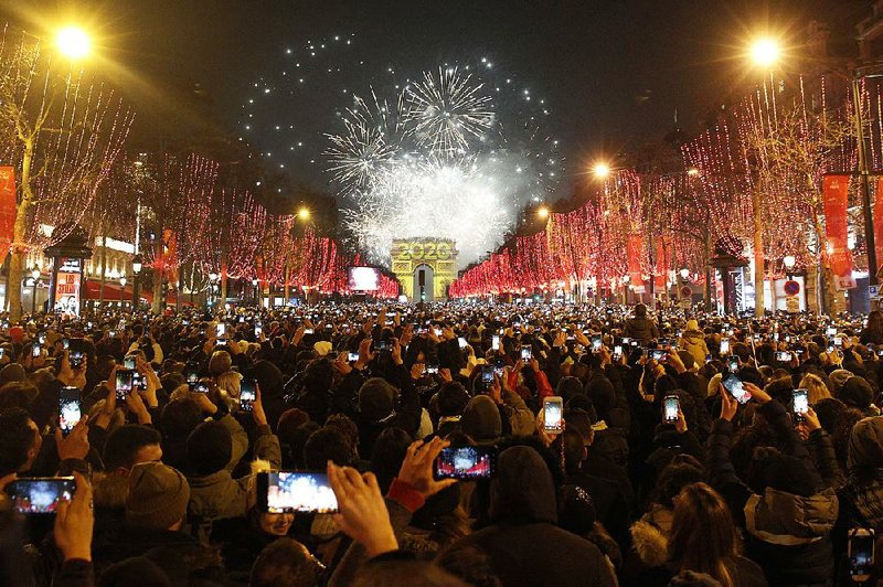 Revelers take in the fireworks display early this morning over the Arc de Triomphe as they celebrate the new year in Paris.
(AP/Christophe Ena)