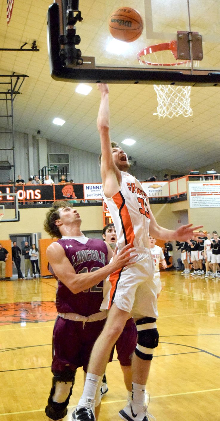 Westside Eagle Observer/MIKE ECKELS Kaleb Furlow (15) snatches a Lions rebound away from Cole Criscom (Wolves 45) during the first quarter of the Gravette-Lincoln varsity game Dec. 3. The Lions lost to the Harrison Goblins, 63-58, in the conference season opener Dec. 20 in Harrison.
