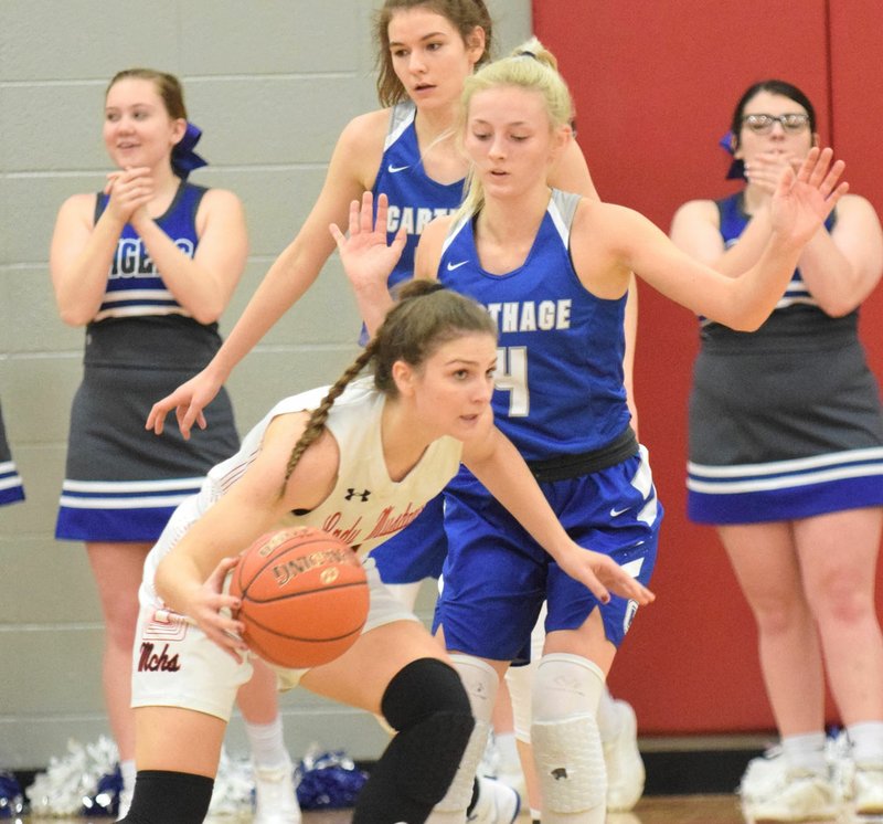 RICK PECK/SPECIAL TO MCDONALD COUNTY PRESS McDonald County's Caitlyn Barton dribbles around Carthage's Karlee Kinder during the Lady Mustangs' 43-35 loss on Dec. 19 at MCHS.