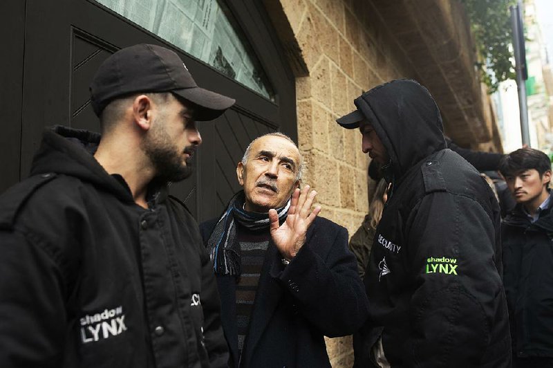 Private security guards flank a man Thursday who identified himself as a family doctor as he enters the home of former Nissan Chairman Carlos Ghosn in Beirut.
(AP/Maya Alleruzzo)