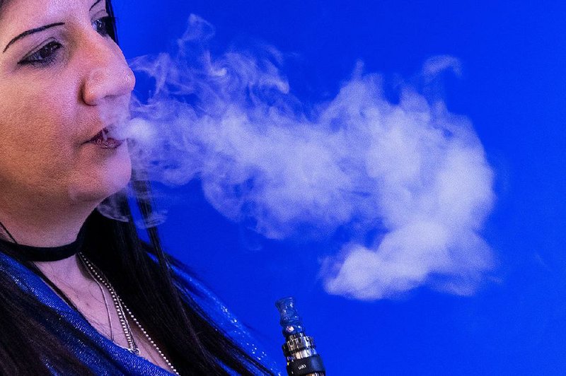 Spike Babaian, owner of the VapeNY.com, vapes Thursday in New York. U.S. health officials will begin cracking down on most flavored e-cigarettes that are popular with underage teenagers, but their plan includes exceptions that benefit vaping manufacturers, retailers and adults who use the nicotine-delivery devices.
(AP/Mary Altaffer) story.lead_photo.caption