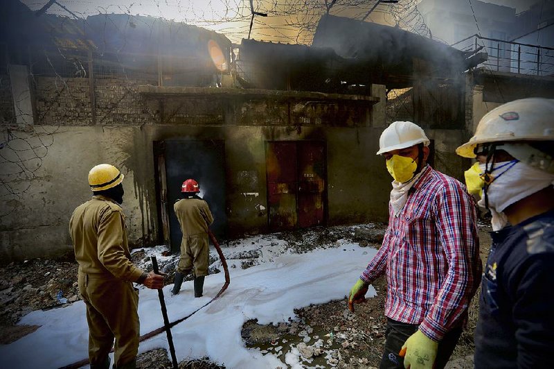 Firefighters work Thursday to extinguish a fire at a factory that manufactures batteries in western New Delhi.
(AP/Manish Swarup)