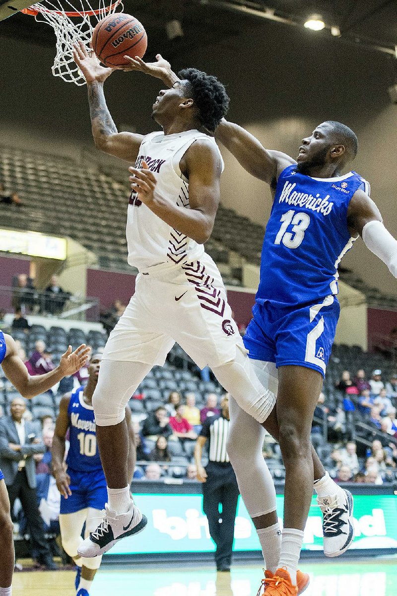 UALR forward Kamani Johnson (left) reaches for a rebound against Texas-Arlington’s Jabari Narcias in the Trojans’ 92-89 victory Saturday at the Jack Stephens Center in Little Rock. Johnson finished with a career-high 30 points, to go along with 13 rebounds and 5 assists. He also made 14 of 16 from the foul line.
(Arkansas Democrat-Gazette/Jeff Gammons)