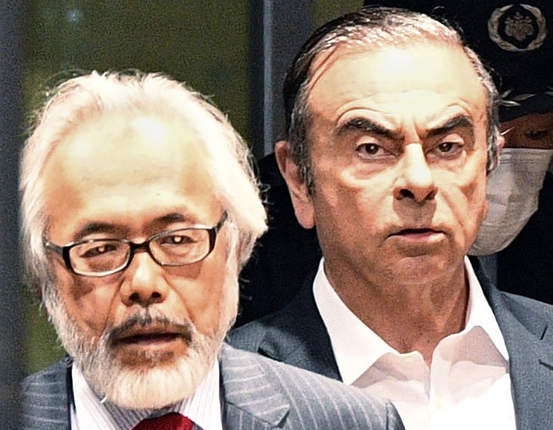 In this April 25, 2019, file photo, former Nissan Chairman Carlos Ghosn, right, walks behind his lawyer Takashi Takano as he leaves the Tokyo Detention Center in Tokyo. Takano said Saturday, Jan. 4, 2020, he felt outraged and betrayed by his client's escape from Japan to Lebanon, but also expressed an understanding for his feelings of not being able to get a fair trial. "My anger gradually began to turn to something else," Takano wrote in his blog post. - Kyodo News via AP